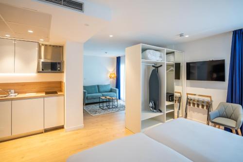Habitación con cama y sala de estar. en abba Apartments Playa de Gros San Sebastián, en San Sebastián