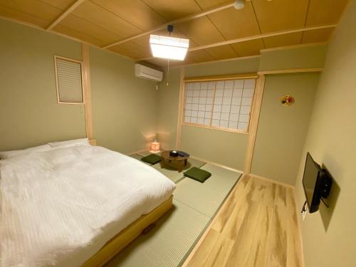 a bedroom with a bed and a tv in it at Toraya in Gero
