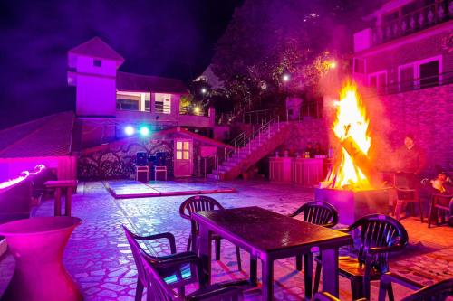 a patio with tables and a fire pit at night at Blue Pine Resort in Lansdowne