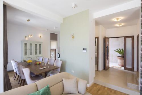 a dining room and living room with a table and chairs at Luxury Villa Flower in Budva