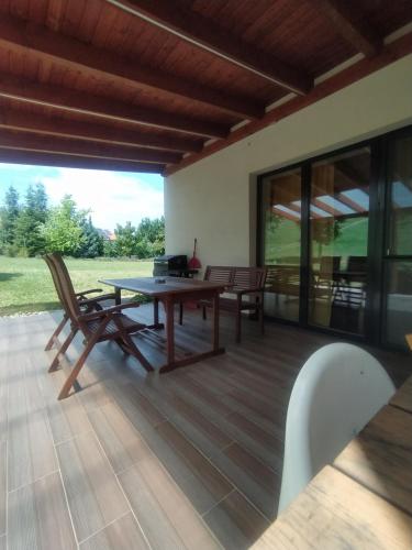 une terrasse avec une table et des chaises en bois. dans l'établissement Bíbor-lak ökoszálláshely, à Pannonhalma