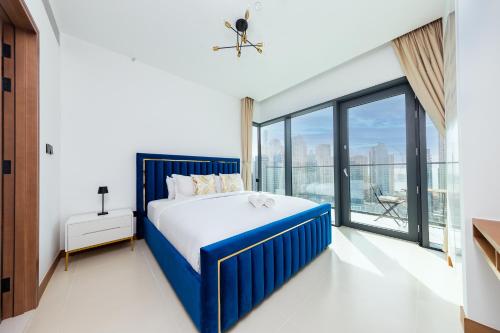 a bedroom with a blue bed and a large window at BRAND-NEW 1 Bedroom with full Marina View in Dubai