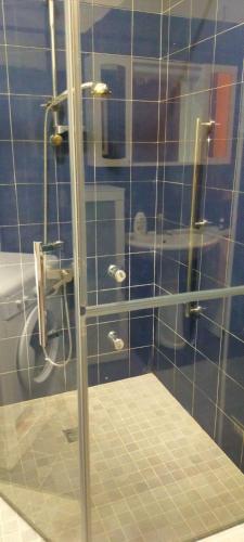 a bathroom with a shower with a blue tiled wall at Appartamento Varese in Varese