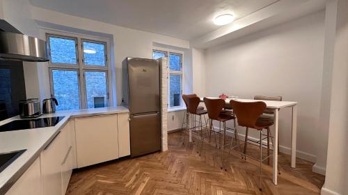 cocina con nevera y mesa con sillas en Carolinas Apartment - Studiestæde 3, en Copenhague