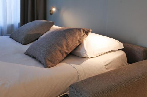 a bed with two pillows on top of it at PRESTIGE BOUTIQUE APARTHOTEL - Piazza Duomo View in Milan