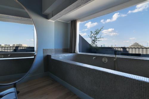 a bathroom with a bath tub and a large window at PRESTIGE BOUTIQUE APARTHOTEL - Piazza Duomo View in Milan