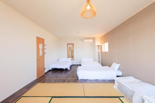 Habitación de hotel con 2 camas y pasillo en 南知多Seaside Villa en Minamichita