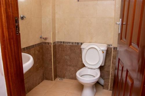 La salle de bains est pourvue de toilettes et d'un lavabo. dans l'établissement Randolph Heights, à Nakuru