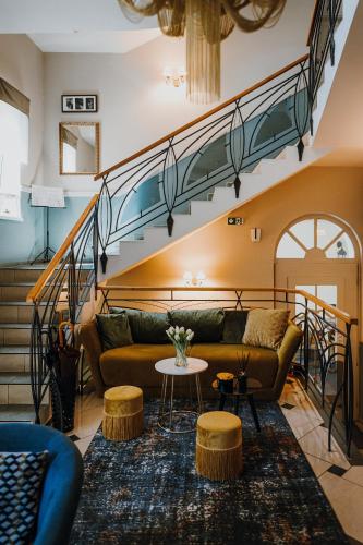 a living room with a couch and a staircase at Hotel Piano in Szeged