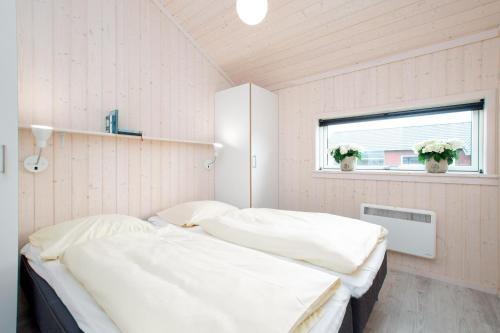 2 Betten in einem weißen Zimmer mit Fenster in der Unterkunft Resort 1 Beach House B 144 in Großenbrode