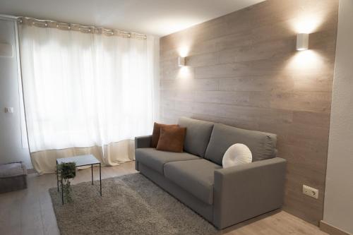 a living room with a couch and a wooden wall at ¡Más céntrico imposible! 6PAX+PK in Andorra la Vella