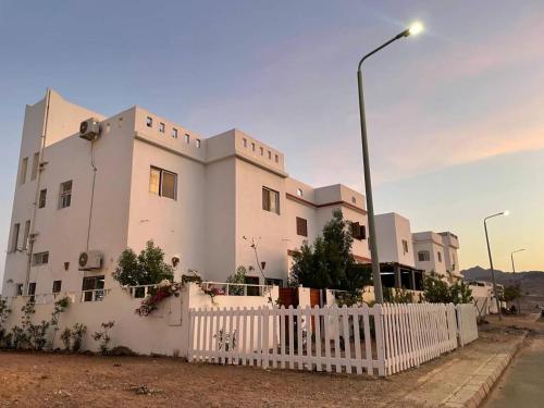 um edifício branco com uma cerca branca e uma luz de rua em Dahab Relax Studio 3 em Dahab