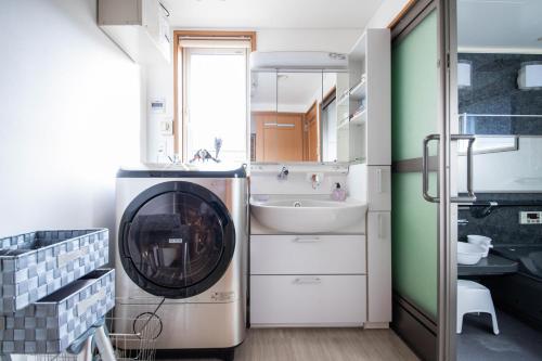 札幌市にあるThe Villa Moiwaの洗面台付きの浴室にある洗濯機