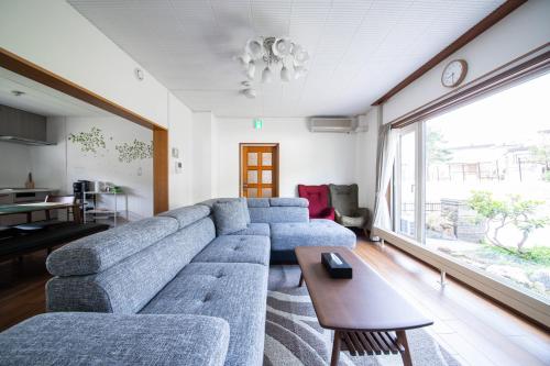 a living room with a blue couch and a table at The Villa Moiwa in Sapporo