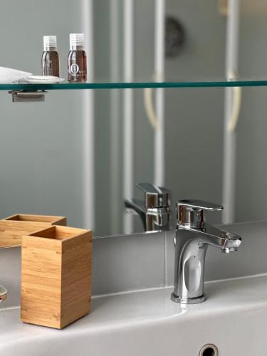 a bathroom sink with a mirror and a sink at Hotel Griselda in Saluzzo