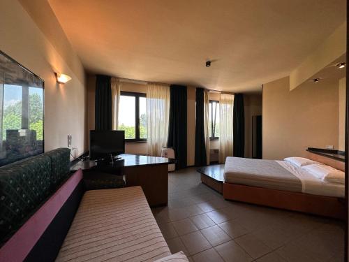 um quarto de hotel com uma cama e um sofá em Hotel Griselda em Saluzzo