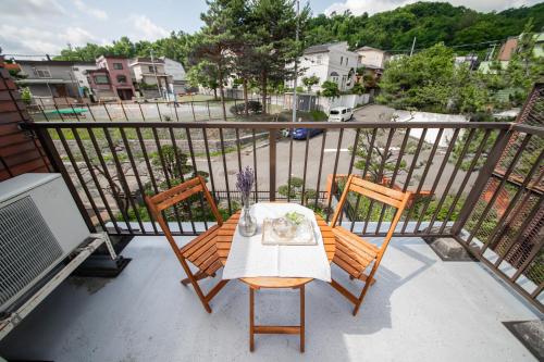 a table and two chairs on a balcony at The Villa Moiwa in Sapporo