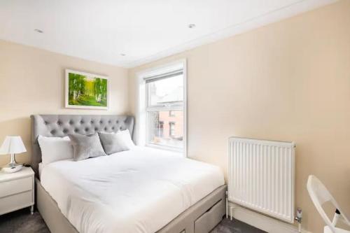 Un dormitorio blanco con una cama grande y una ventana en Nice 2 bedroom house in Stowmarket, en Stowmarket