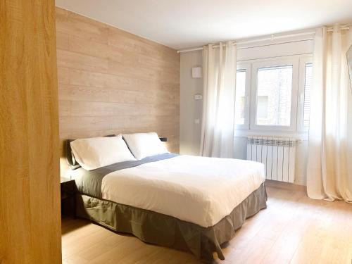 um quarto com uma cama com lençóis brancos e uma janela em ¡Más céntrico imposible! 6PAX+PK em Andorra-a-Velha
