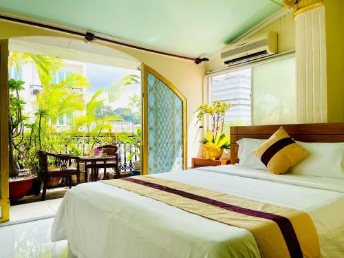 1 dormitorio con 1 cama grande y balcón en Hải Nam Hotel (Sài Gòn), en Ho Chi Minh