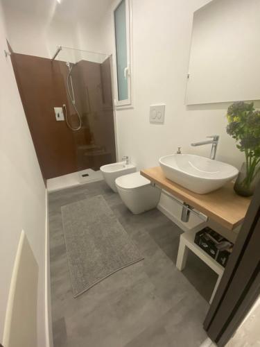 a bathroom with two toilets and a sink and a mirror at LuLu Naxos Apartment in Giardini Naxos