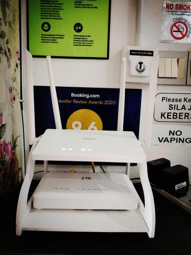 a white chair sitting in front of a wall at The Floral Home in Melaka