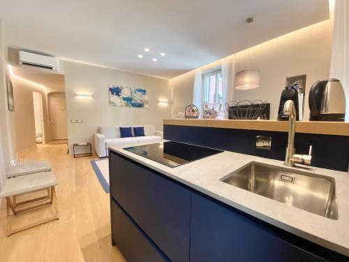 uma cozinha com um lavatório e uma sala de estar em San Giorgio Uno 60mq 1b/1b em Portofino