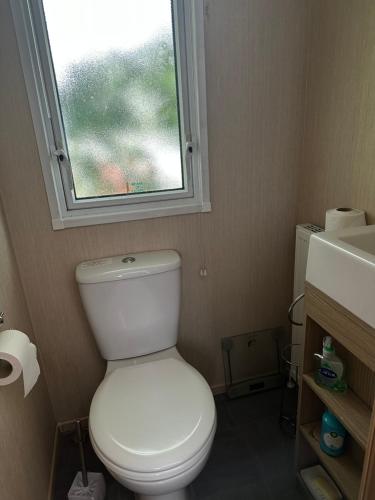 bagno con servizi igienici bianchi e finestra di Happy Place a West Mersea