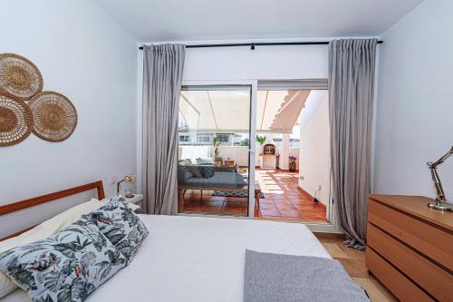 a bedroom with a bed and a sliding glass door at Precioso apartamento junto a Starlite Marbella by Rent Me in Marbella