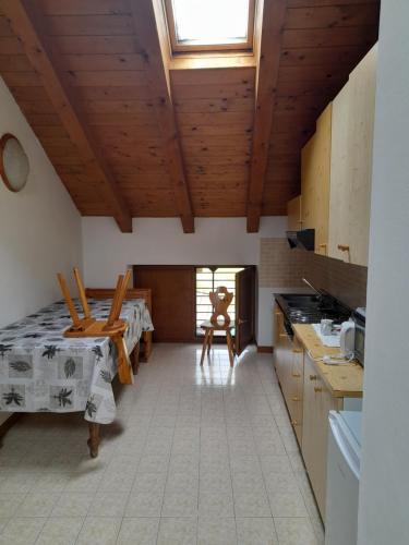 een keuken met houten plafonds en een tafel en stoelen bij Agriturismo Val di Ferro in Arsiero
