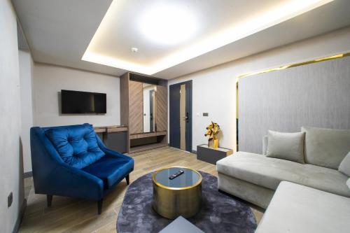 un soggiorno con divano e sedia blu di MAD INN HOTEL & SPA a Ankara