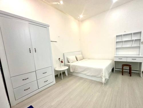 a white bedroom with a bed and a desk at POOLseaview - 1A Blue Sea Apart in Da Nang