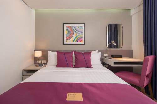 a hotel room with a large bed and a desk at The Belamy House Managed by HII in Manila