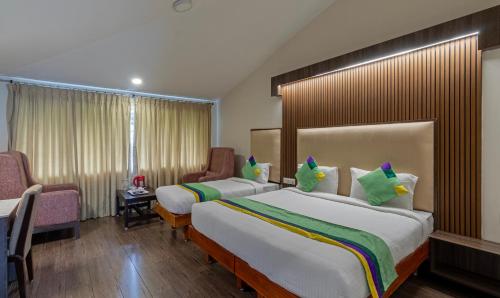 a hotel room with two beds and a window at Treebo Kodai Kings Park, 650 M From Kodai Lake in Kodaikānāl