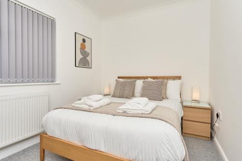 a bedroom with a bed with two towels on it at Beautiful 3 Bed Apartment - Large Outside Terrace & Parking - The Perfect Choice For Families, Small Groups & Contractors - Close To Ventnor Beach in Ventnor