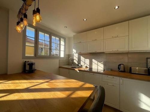 une cuisine avec des armoires blanches et une table en bois dans l'établissement Le Provence, à Aix-en-Provence