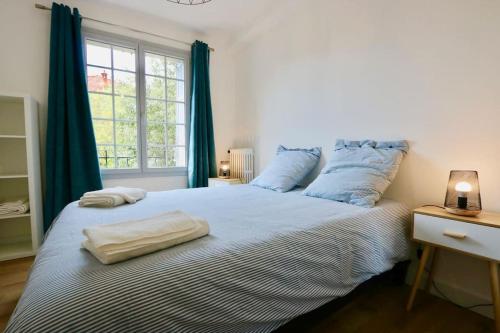 une chambre avec un grand lit avec des rideaux bleus dans l'établissement Le Provence, à Aix-en-Provence