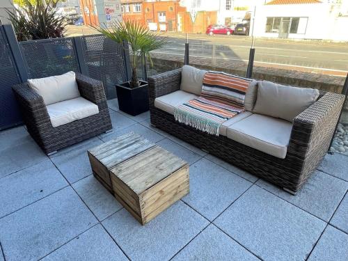 two wicker chairs and a coffee table on a patio at Harbourside Hideaway - Superb Flat with Terrace in Bristol