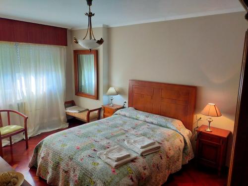 a bedroom with a bed with two towels on it at Piso Corunna Easy Parking wifi in Arteixo