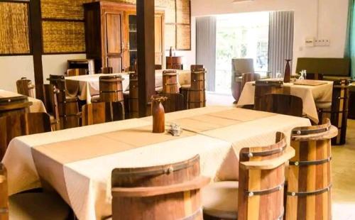 Espace Menamasoandro في موروندافا: غرفة طعام بها طاولات وكراسي وغرفة بها