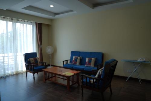 een woonkamer met een bank, stoelen en een tafel bij Shayona Apartments Limited in Nairobi
