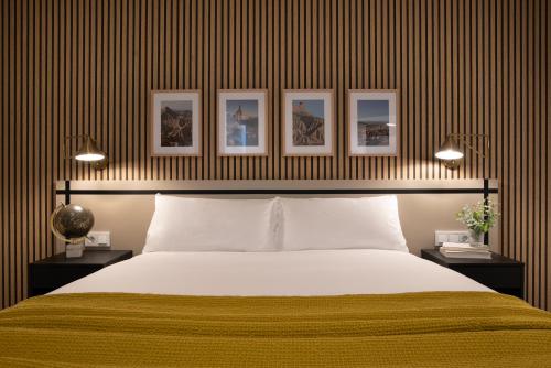 1 dormitorio con 1 cama y 3 cuadros en la pared en Apartamentos4U Tudela Plaza Parking Incluido en Tudela