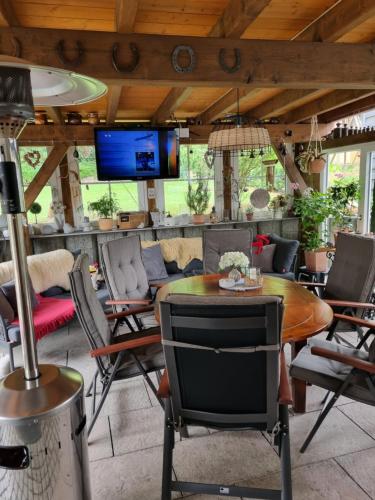 a patio with chairs and a table and a tv at Ferienwohnung Romy Müller in Mohlsdorf