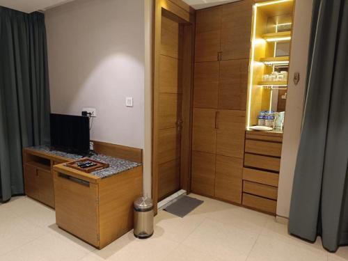 a room with a desk with a computer and a closet at Hotel Mayfair Tower in Kolkata