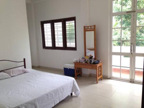 a bedroom with a bed and a table with a mirror at Vegan Stay by The Vegan Kitchen by Sulo in Boralesgamuwa