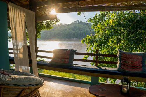 a porch with a window with a view of a river at Ock Pop Tok Mekong Villa in Luang Prabang