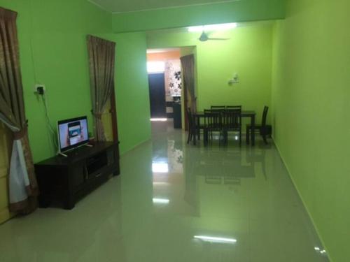 a living room with green walls and a dining room at D'FIEZA HOMESTAY KEMAMAN in Cukai