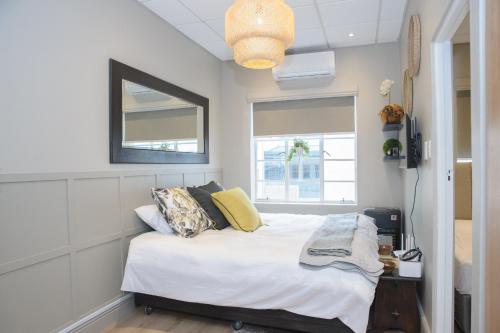 1 dormitorio con cama, espejo y ventana en Royal Pearl, Insta-worthy APT en Paarl