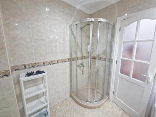 La salle de bains est pourvue d'une douche avec une porte en verre. dans l'établissement La casa de Alcorac, à Las Palmas de Gran Canaria