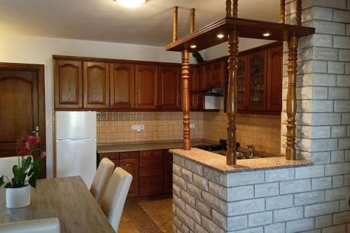 a kitchen with wooden cabinets and a stone counter top at Apartmani Srdarović 3 in Drage